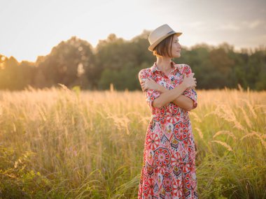Kendini kucaklayan genç bir kadın, hareket halindeki bir aşk, akıl sağlığı savunucusu, iç huzuru bulmak için Avrupa 'nın kırsal kesimlerinde kendi kendine bakım uygulayan.