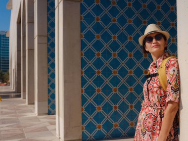 Abu Dabi 'de Qasr Al Hosn Parkı' nı keşfeden genç bir kadın. Yeşillik ve tarihi simgelerle çevrelenmiş, kentin kalbindeki sakin atmosfer ve Emirati mirasının tadını çıkarıyor..