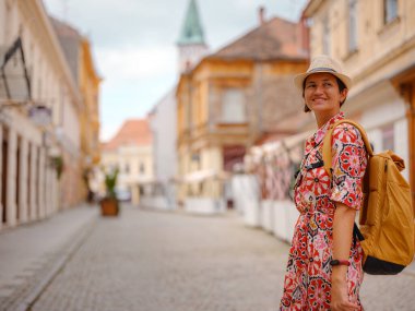 Varazdin sokaklarında yaz günü eski, tarihi şehir merkezinde yürüyen güzel bir kadın. Bu güzel caddeleri keşfeden turist, Hırvat kentinin rahat ve kültürel havasını yaşıyor..