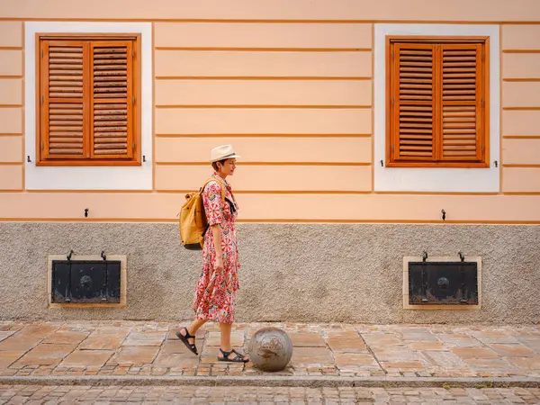 Varazdin sokaklarında yaz günü eski, tarihi şehir merkezinde yürüyen güzel bir kadın. Bu güzel caddeleri keşfeden turist, Hırvat kentinin rahat ve kültürel havasını yaşıyor..