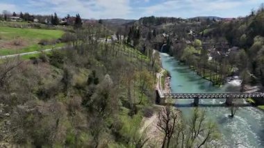 Korana Nehri 'nin insansız hava aracı manzarası Slunj yakınlarındaki engebeli arazide dönüyor. Ağaçlar kıştan dolayı hala çıplakken, berrak su ve yosunlu bankalar yaklaşan baharı ima ediyorlar. Hırvat doğası.
