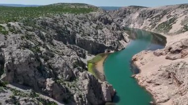 Krnjeza ve Krupa nehirlerinin birleştiği hava manzarası. Dolambaçlı Zrmanja nehrinin havadan çekimleri derin kanyonu, bereketli bahar renklerini ve uzak yolları kesiyor.