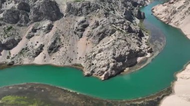 Krnjeza ve Krupa nehirlerinin birleştiği hava manzarası. Dolambaçlı Zrmanja nehrinin havadan çekimleri derin kanyonu, bereketli bahar renklerini ve uzak yolları kesiyor.