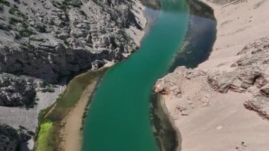 Obrovac 'tan nehir ağzı antenine kadar Zrmanja kanyonu nehri. Dolambaçlı Zrmanja nehrinin havadan çekimleri derin kanyonu, bereketli bahar renklerini ve uzak yolları kesiyor.