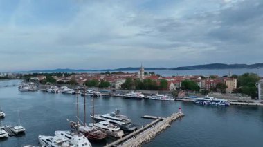 Zadar marinası ve yukarıdan görünen antik kasaba. Kıyı ilkbahar atmosferindeki Zadars rıhtımı, kırmızı çatılar, marina ve Roma mirasının güneşli hava görüntüleri