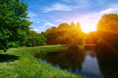 Şehir parkındaki göl mavi gökyüzü arka planında