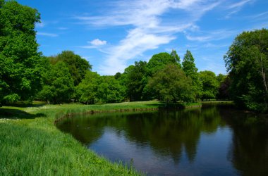 Şehir parkındaki göl mavi gökyüzü arka planında