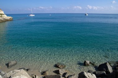 Mavi deniz ve kayaların manzarası.