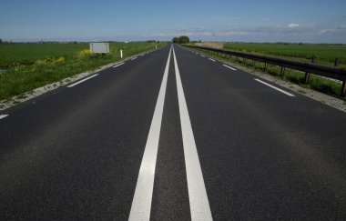 Asfalt araba yolu ve mavi gökyüzündeki bulutlar 