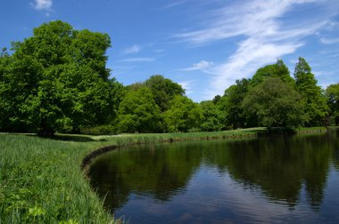 Şehir parkındaki göl mavi gökyüzü arka planında