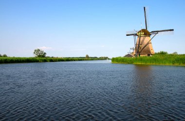 Hollanda 'da deniz kenarında güneşli bir günde yel değirmeni