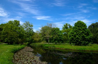 Şehir parkındaki göl mavi gökyüzü arka planında