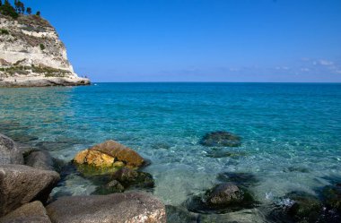 Mavi deniz ve kayaların manzarası.