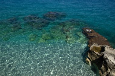 Mavi deniz ve kayaların manzarası.