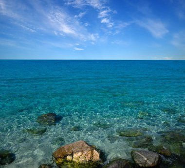 Mavi deniz ve kayaların manzarası.