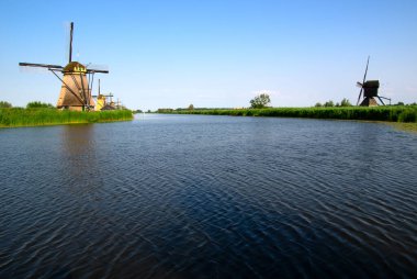 Hollanda 'da deniz kenarında güneşli bir günde yel değirmeni