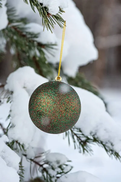 在云杉和模糊的背景上挂着绿色闪光的圣诞球 — 图库照片