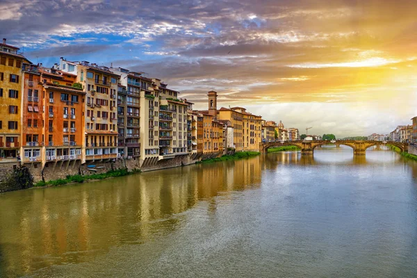 Scenic sunset cityscape over Arno River, St Trinity Bridge and colorful old houses along the river in Florence city, Tuscany, Italy                               