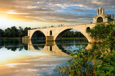 Beautiful evening landscape of the Avignon Bridge (Pont d'Avignon Bridge) and Chapel of Saint Nicholas on the Rhone river at sunset in Avignon city, France                         