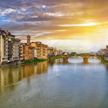 Scenic sunset cityscape over Arno River, St Trinity Bridge and colorful old houses along the river in Florence city, Tuscany, Italy                               