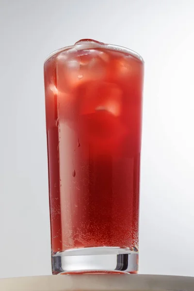 glass of red iced drink on table