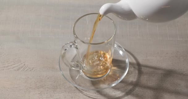 Chá Preto Derramando Uma Xícara Vidro Bule Chá — Vídeo de Stock