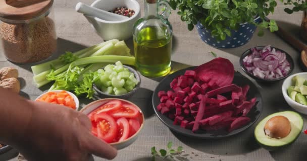 各种新鲜生菜和坚果放在厨房木制桌子上 一套素食配料 西红柿碗放在桌子上 慢动作 — 图库视频影像
