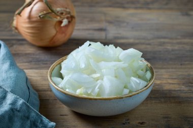 Kırsal ahşap mutfak masasında dilimlenmiş bir kase tatlı soğan.