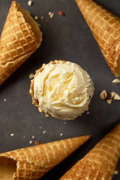 vanilla ice cream ball and waffle cones on grey background, top view