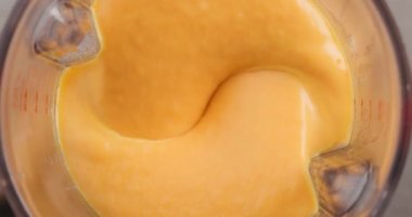 process of making vegetable cream soup. boiled carrot, potato and onion mixing in blender, top view