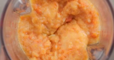 process of making vegetable cream soup. boiled carrot, potato and onion mixing in blender, top view
