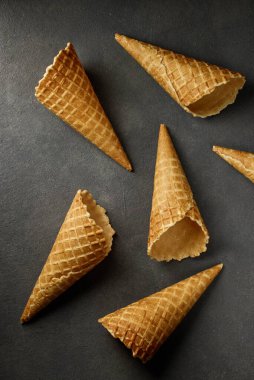 ice cream waffle cones on dark grey table background, top view