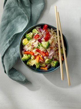 bowl of fried rice with vegetables on white kitchen table, top view