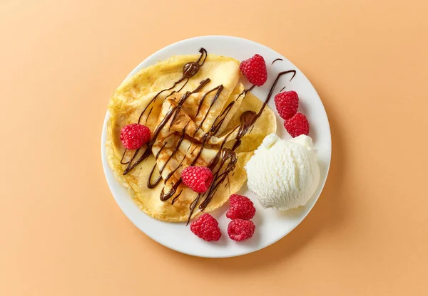 아이스크림 라즈베리가 크레이프와 초콜릿 소스로 장식된 화이트 플레이트 — 스톡 사진