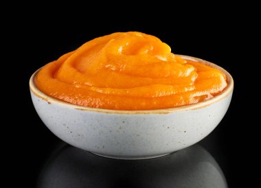 Siyah arka planda izole edilmiş bir kase sebze püresi