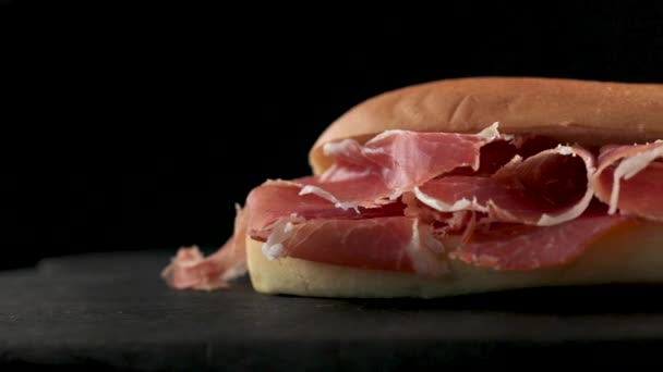Siyah Tahta Üzerinde Dilimlenmiş Spanyol Jambonlu Sandviç — Stok video