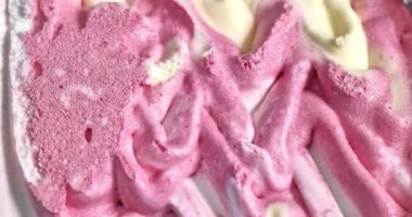 yaban mersini, mascarpone ve vanilyalı dondurma metal kaşıkla konteynırdan çıkartılıyor.