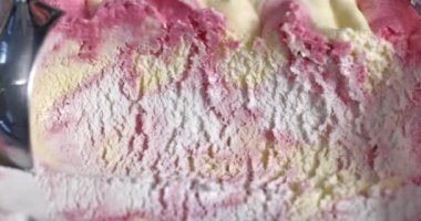 yaban mersini, mascarpone ve vanilyalı dondurma metal kaşıkla konteynırdan çıkartılıyor.
