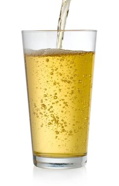 Beyaz arka planda izole edilmiş bardağa dökülen taze elma suyu.