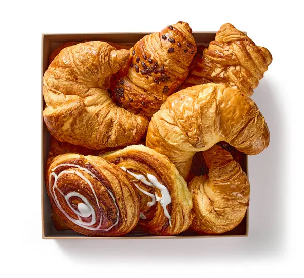 box of various freshly baked pastries isolated on white background, top view