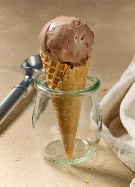 ベージュカラーの背景にワッフルコーンの自家製バナナとチョコレートアイスクリームのクローズアップ — ストック写真