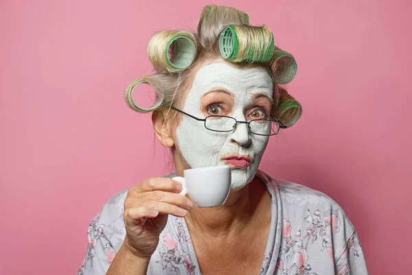 Mulher Sênior Engraçado Com Máscara Facial Cosmética Xícara Café Fundo — Fotografia de Stock