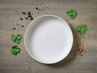 Boş ışık kasesi ve baharatlar ahşap mutfak masasında, üst manzara.