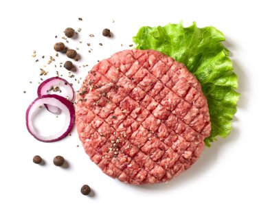 Beyaz arka planda marul yaprağı ve baharatlı taze çiğ hamburger eti.