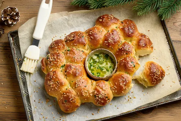 freshly baked christmas bread with melted butter with garlic and parsley on baking try