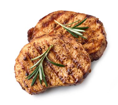 Beyaz arka planda izole edilmiş biberiyeli ve baharatlı taze ızgara biftekler.