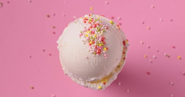 Ванильное Мороженое Мяч Падающим Сахаром Посыпки Розовом Фоне Вид Сверху — стоковое видео