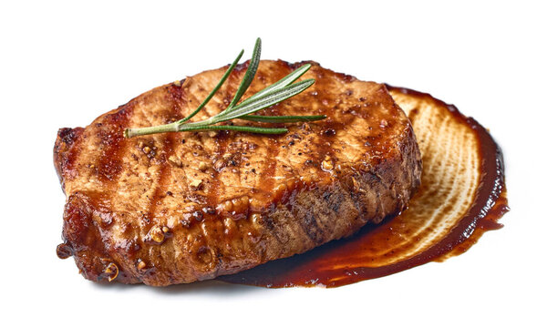 Freshly grilled steak with rosemary, spices and barbecue sauce isolated on white background