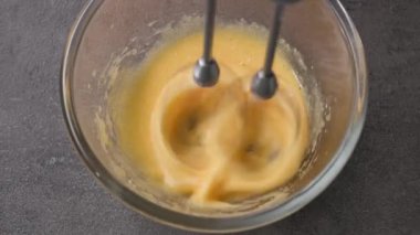 Şef çırpılmış yumurta sarısını cam bir kasede şekerle karıştırır. Yiyeceklere yaklaş, yakınlaştır.