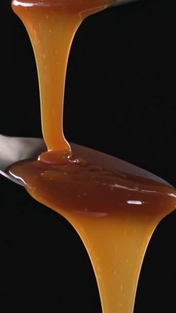 Melted Caramel Sauce Flowing Metal Spoon Black Background Food Close — Stock Video